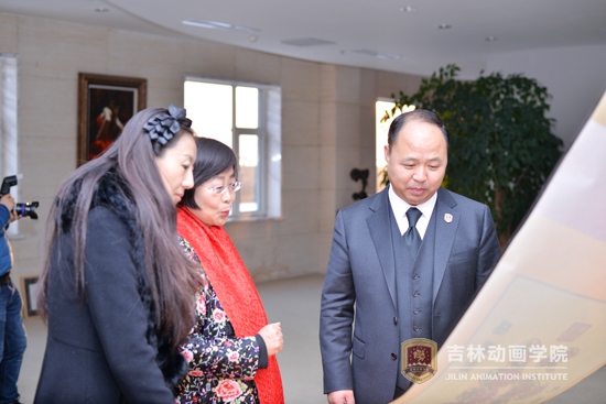 3艺术家周淑英向董事长郑立国讲解剪纸艺术.jpg